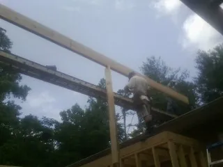 Carpenter setting a ridge beam over a new addition frame — Ice Dam Removal by Roofing Brothers in Cadiz
