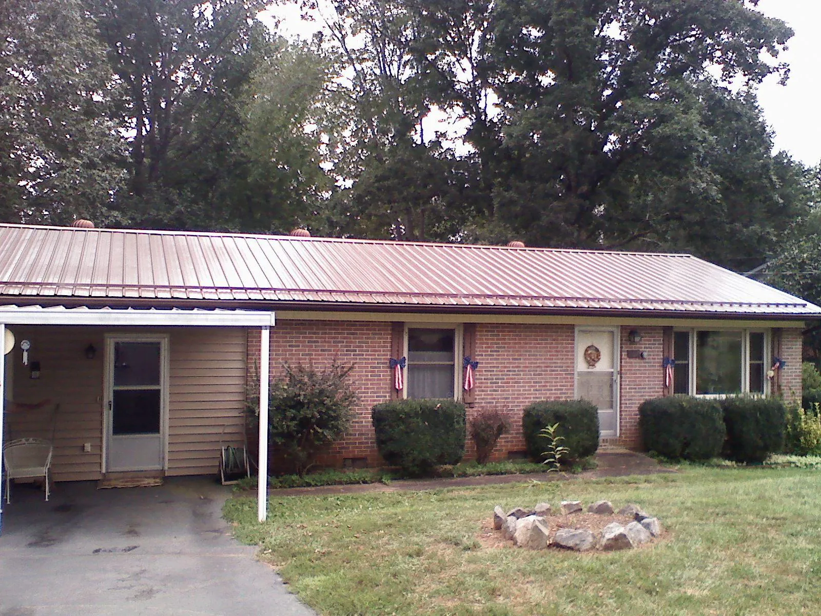 Bronze metal roof and carport on a brick ranch home — Roof Repair work by our crew in Cadiz